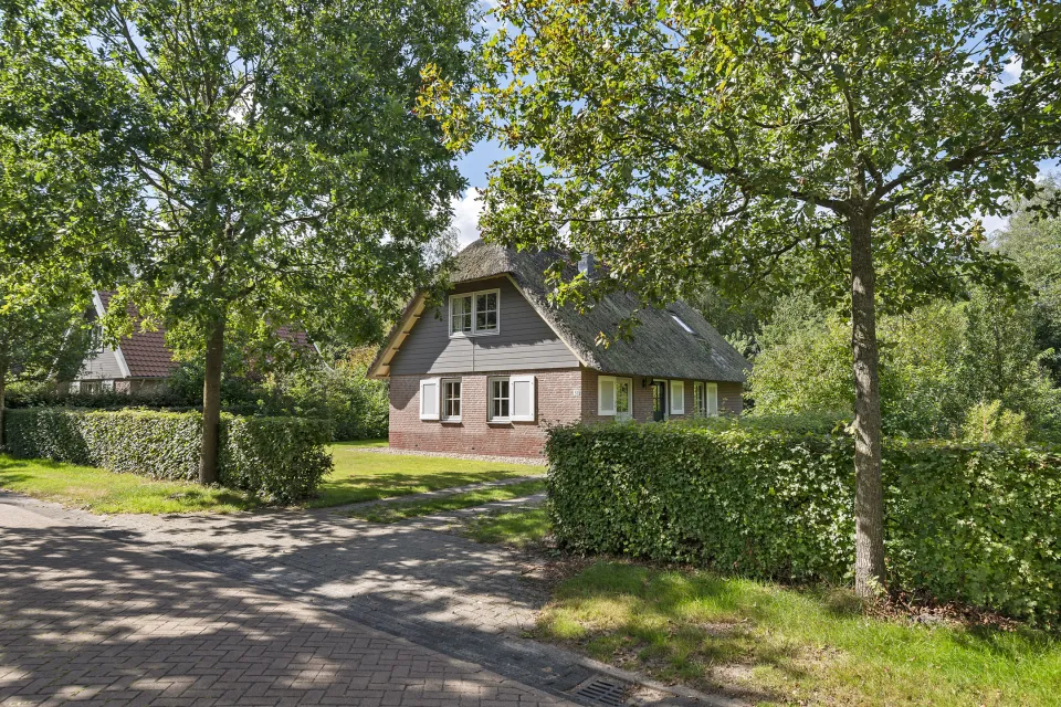 Vrijstaande vakantiewoning Keizersmantel aan Koele 32 met rieten dak tussen de bomen op Buitenplaats de Hildenberg