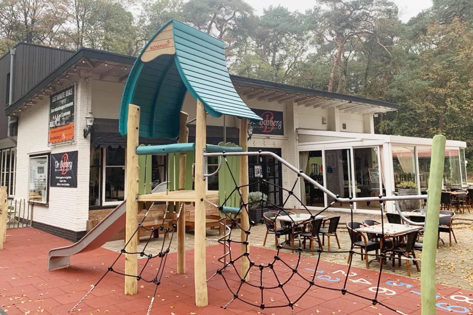 Terras van het restaurant op de Bosberg in Appelscha met houten speeltoestellen voor kinderen