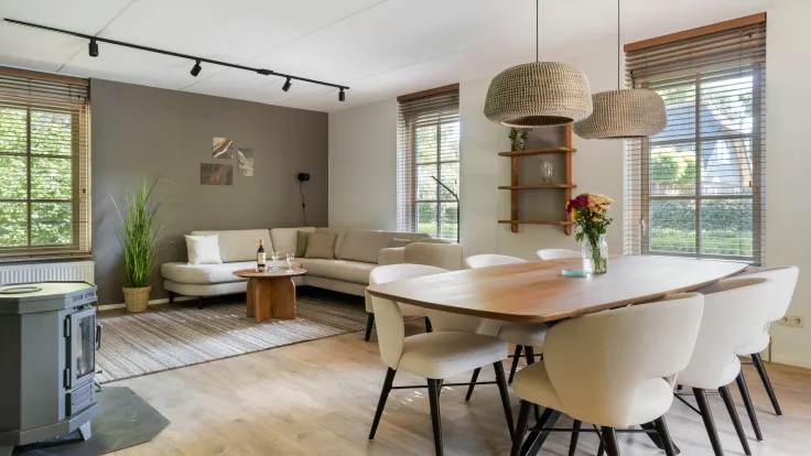 Grote eettafel met stoelen en een open keuken in vakantiewoning Dagpauwoog aan Gruun 22