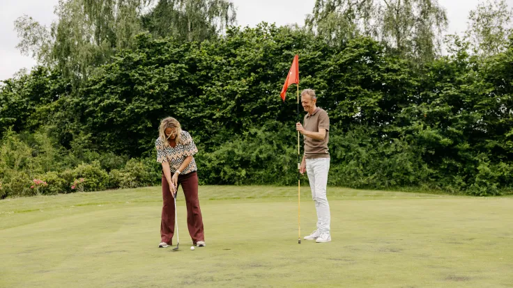Twee vrouwen spelen golf op de green van golfpark Hildenberg bij Appelscha